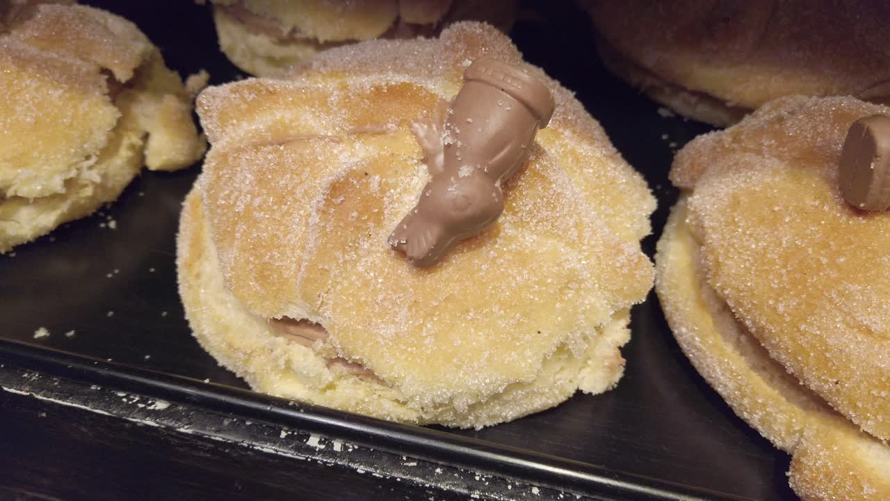 Sugary pastries with cute chocolate figure toppings in bakery display