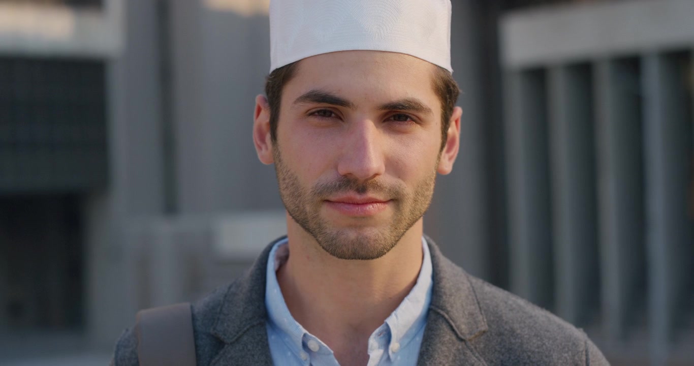 Ritratto di un giovane uomo musulmano che indossa un copricapo kufi