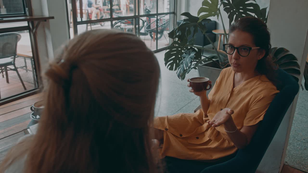 To kvinder, der snakker over kaffe på en cafe
