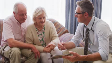 senior couple talking with a doctor in retirement house