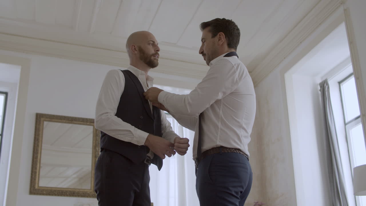 pareja gay feliz vestida con trajes formales para la boda