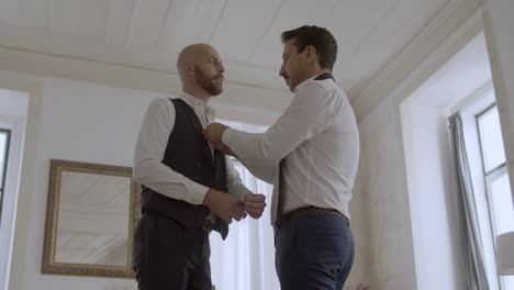 happy gay couple dressing in formal suits for wedding