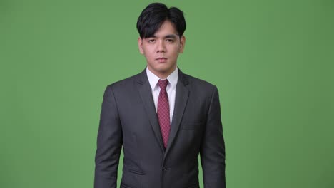 young handsome asian businessman showing middle fingers