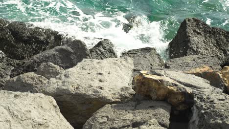 las olas del océano atlántico golpean la costa rocosa de tenerife, en cámara lenta.