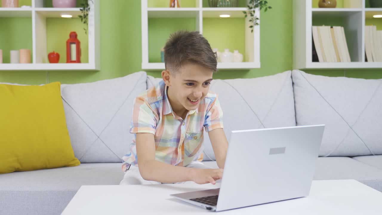 The boy is secretly using his father's laptop. Curious boy.
