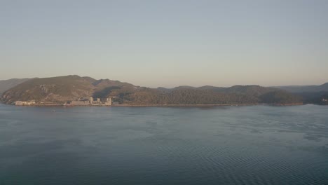 트로이아 반도, 리스본, 포르투갈에서 산티아고 요새 뒤 산에 반사된 멋진 저녁 하늘