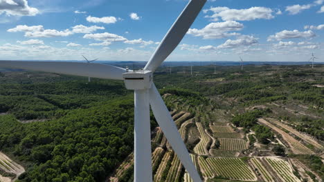 perspective close-up of wind turbine blades with countryside in background, trucafort, pradell de la teixeta, tarragona in spain