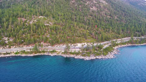 aerial view of road and forest on the shoreline of lake tahoe, beautiful natural landscape deep blue water