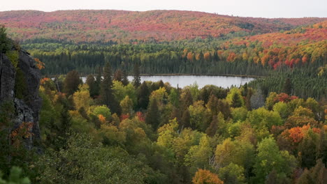 slow pan of remote lake surrounded by fall foliage