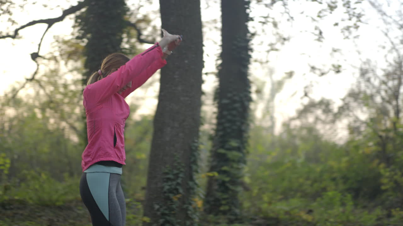 Young woman stretching and warming up in a park before her run