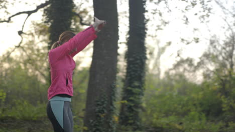 young woman stretching and warming up in a park before her run