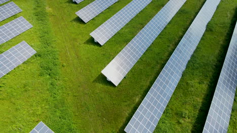 Ojo-De-Pájaro-Aéreo-Del-Panel-Solar-Granja-Sol-Conservación-De-Energía-Fuente-De-Alimentación-Puesta-De-Sol-En-Montañas-Verdes