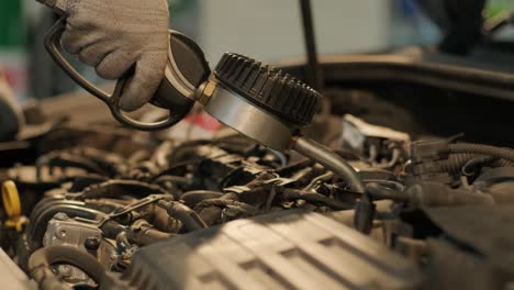 el mecánico de automóviles está cambiando el aceite del motor en un motor en la estación de automóviles. cambio de aceite automatizado con equipos modernos