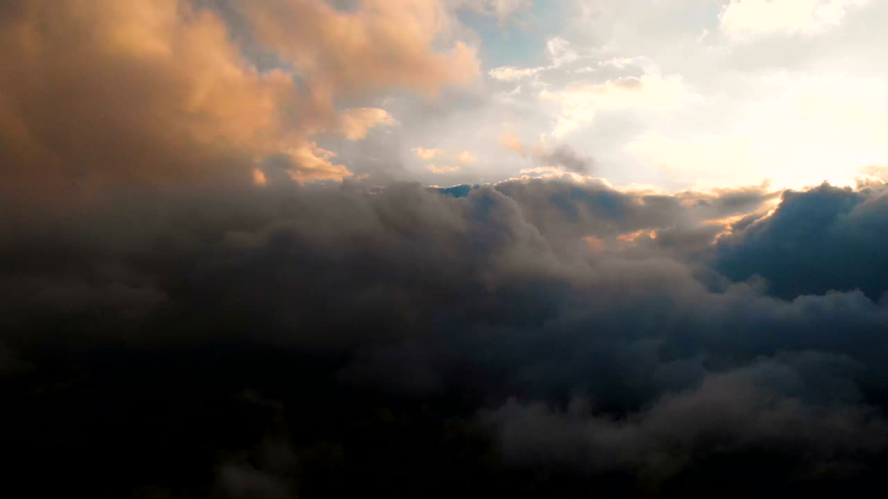 la cámara se extiende a través de las nubes de lluvia de la noche al atardecer por encima de los niveles de nubes. fabuloso vuelo en las nubes. vista aérea