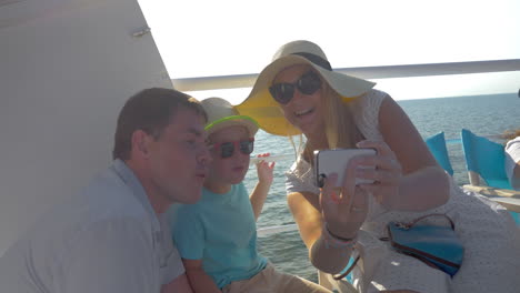 familia tomando selfies móviles en el barco