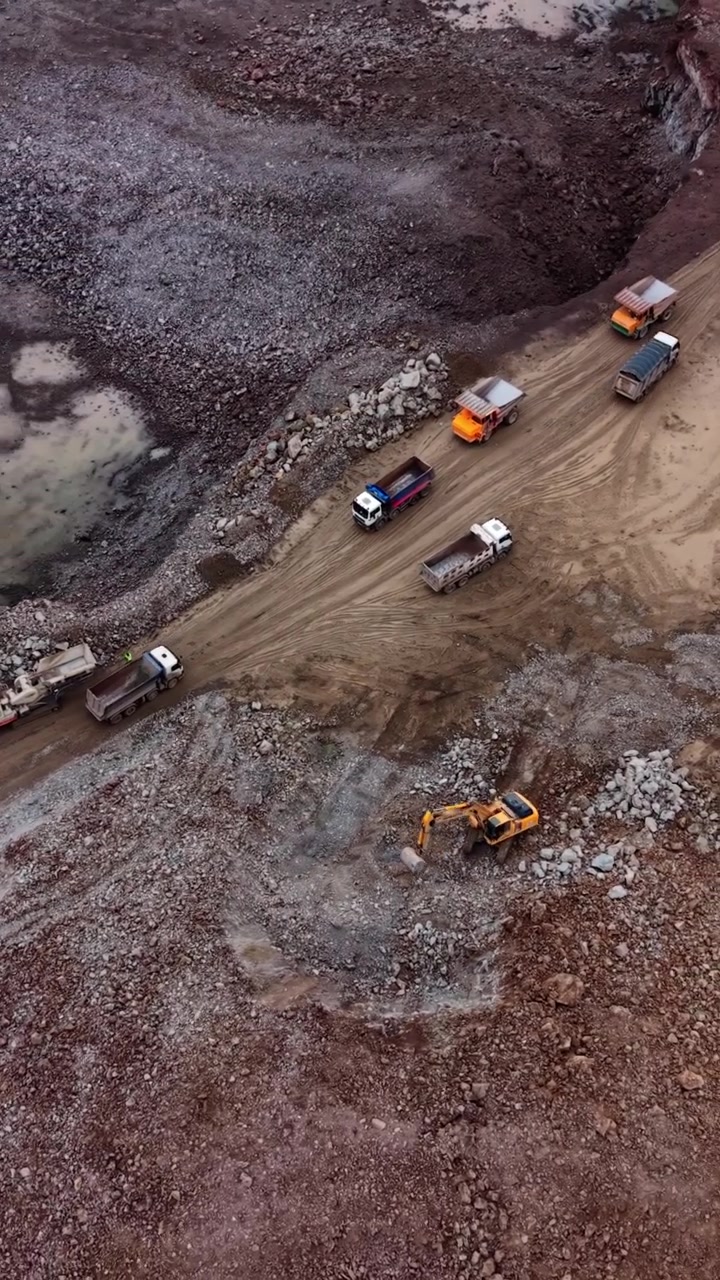 Aerial View of Heavy Machinery and Dump Trucks Operating in a Quarry
