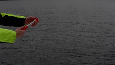 Crewmember-in-emergency-launch-maritime-distress-flare-at-sea,-close-up