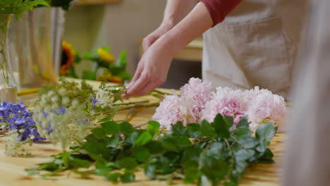 femme fleuriste faisant un arrangement floral pour un client