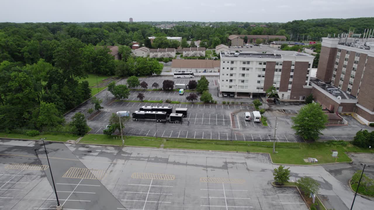вид с воздуха на два туристических автобуса, припаркованных в жилом районе - приближение, съемка с дрона