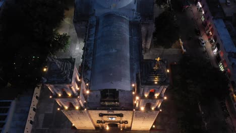 nighttime aerial camera looking straight down and then pulling back and pitching up showing the catedral de san gervasio in valladolid, yucatan, mexico