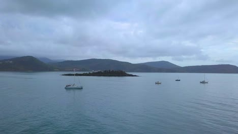 Drohne-Fliegt-An-Einem-Bewölkten-Tag-In-Richtung-Einer-Kleinen-Insel-Vor-Der-Küste-Von-Airlie-Beach,-Shute-Harbour,-Nord-Queensland