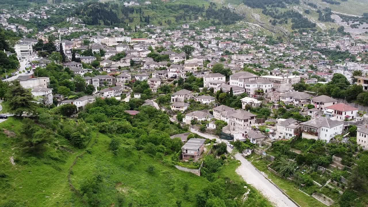 Flygvy över Gjirokaster, Albanien, som visar stadens traditionella stenhus, gröna kullar och slingrande gator