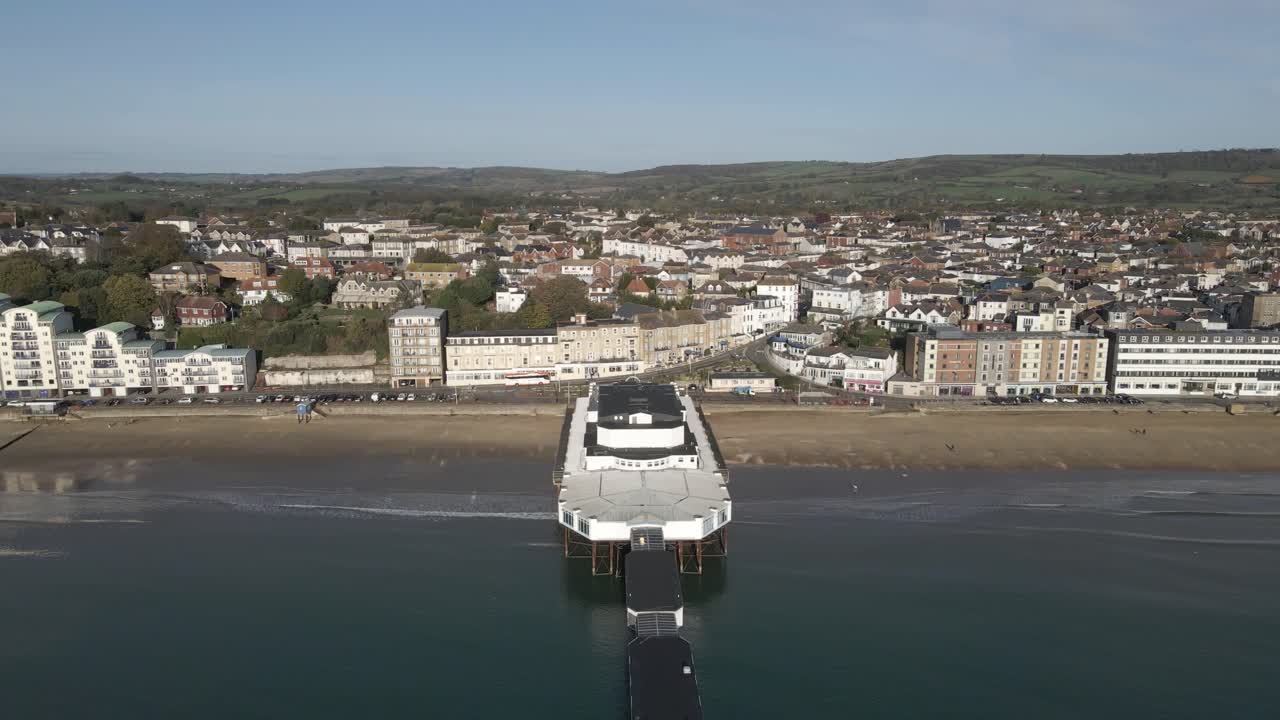 Vista aerea di Sandown, località balneare e parrocchia civile sulla costa sud-orientale dell'Isola di Wight, in Inghilterra. Vista del molo di Sandown con drone che si muove all'indietro sopra il molo