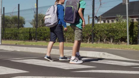 two boys with school bags crossing the road