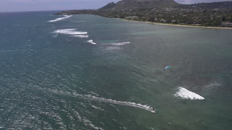 Aerial-view-of-kitesurfer-sailing-along-Waialae-beach-in-Oahu-Hawaii