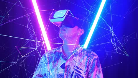 vr, futuristic, entertainment concept. excited asian man using virtual reality headset with neon light at the background