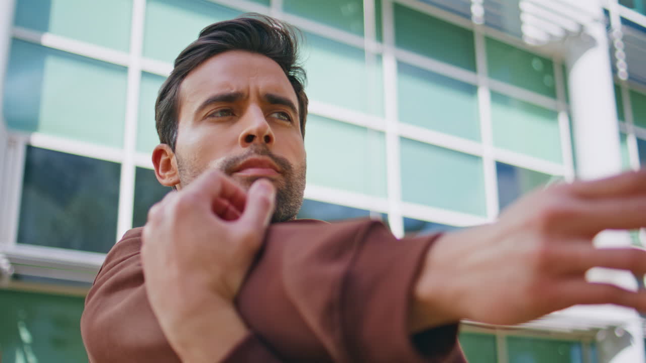 Handsome sportsman stretching arms on street workout closeup. Bearded athlete