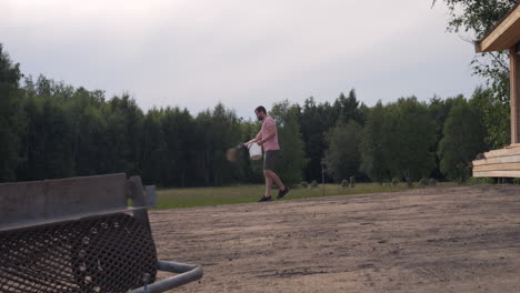 man sowing seeds for lawn in garden