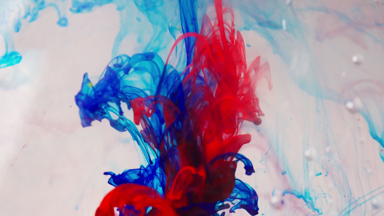 Vortici di inchiostro rosso vivo e blu nell'acqua, macro, arte astratta