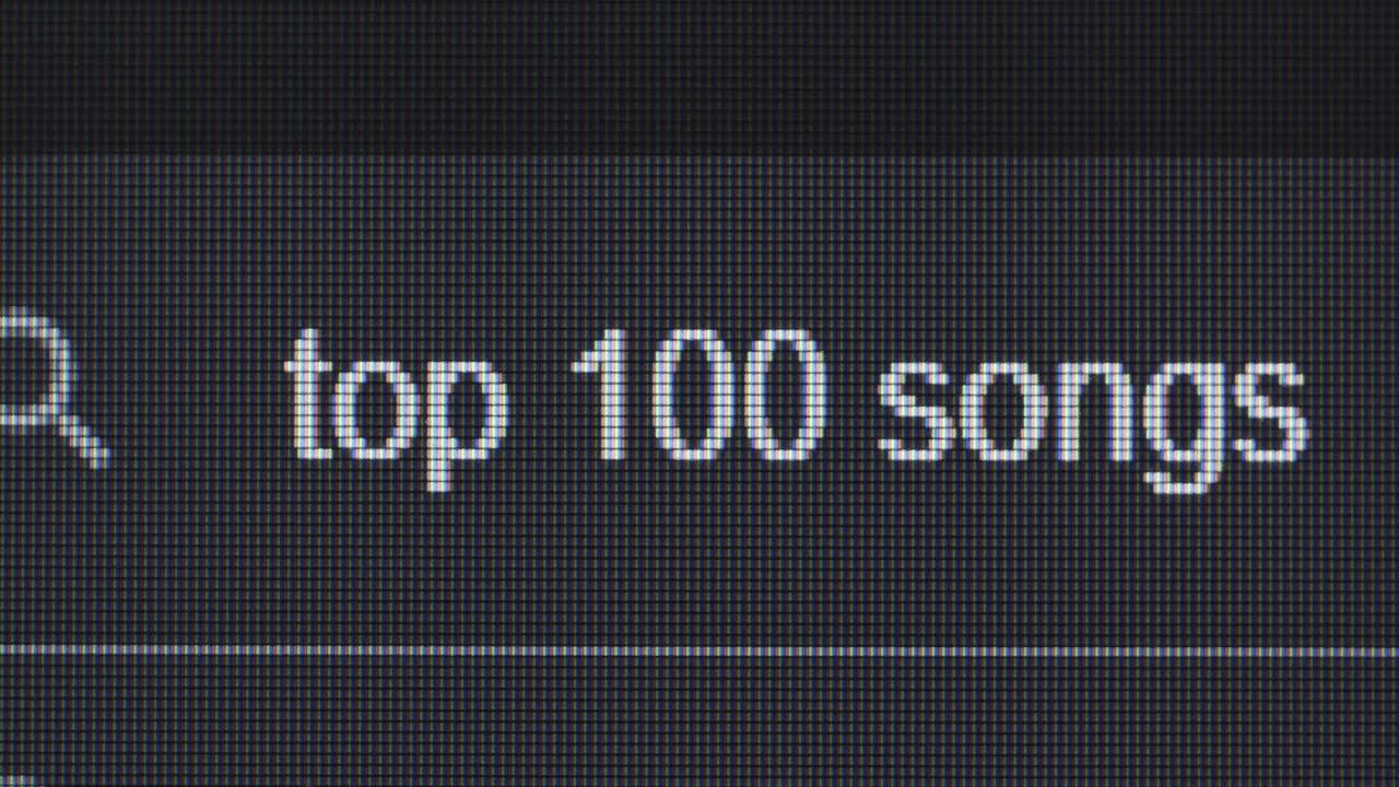 Close-up of a computer screen displaying text "Top 1" and "100 songs".