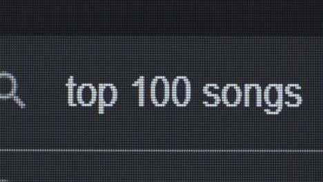close-up of a computer screen displaying text "top 1" and "100 songs".