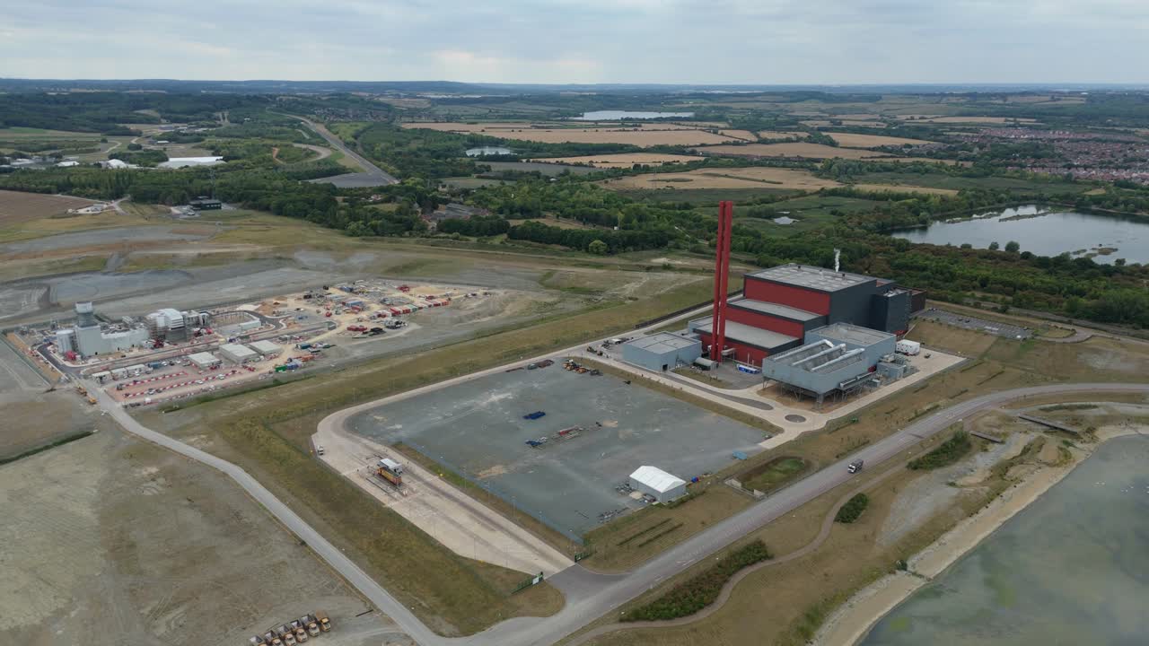 High altitude drone aerial video of Bedford UK power plant with chimney stacks, smoke plumes, fossil fuel electricity generation and industrial buildings