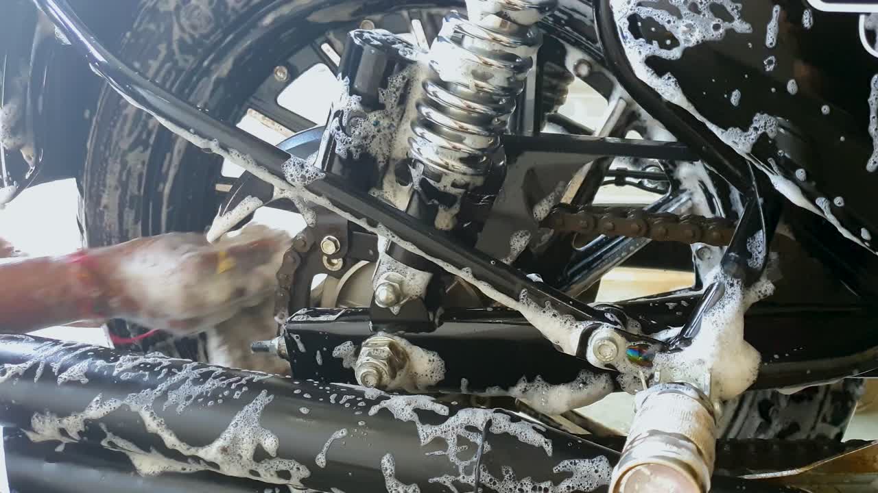 샴푸로 자전거 뒷바퀴를 세척하는 작업자