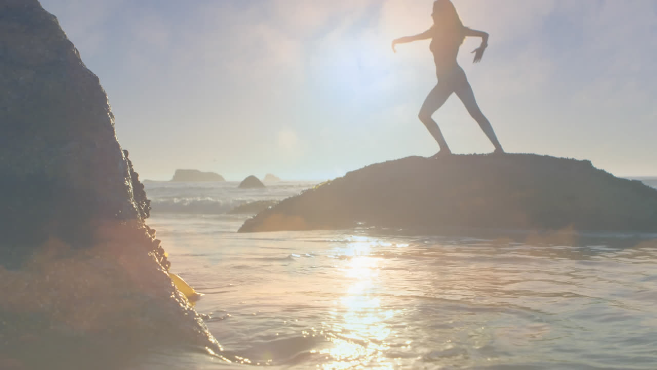 은 날 바가의 바위 위에 서서 요가를 연습하는 여성의 실루