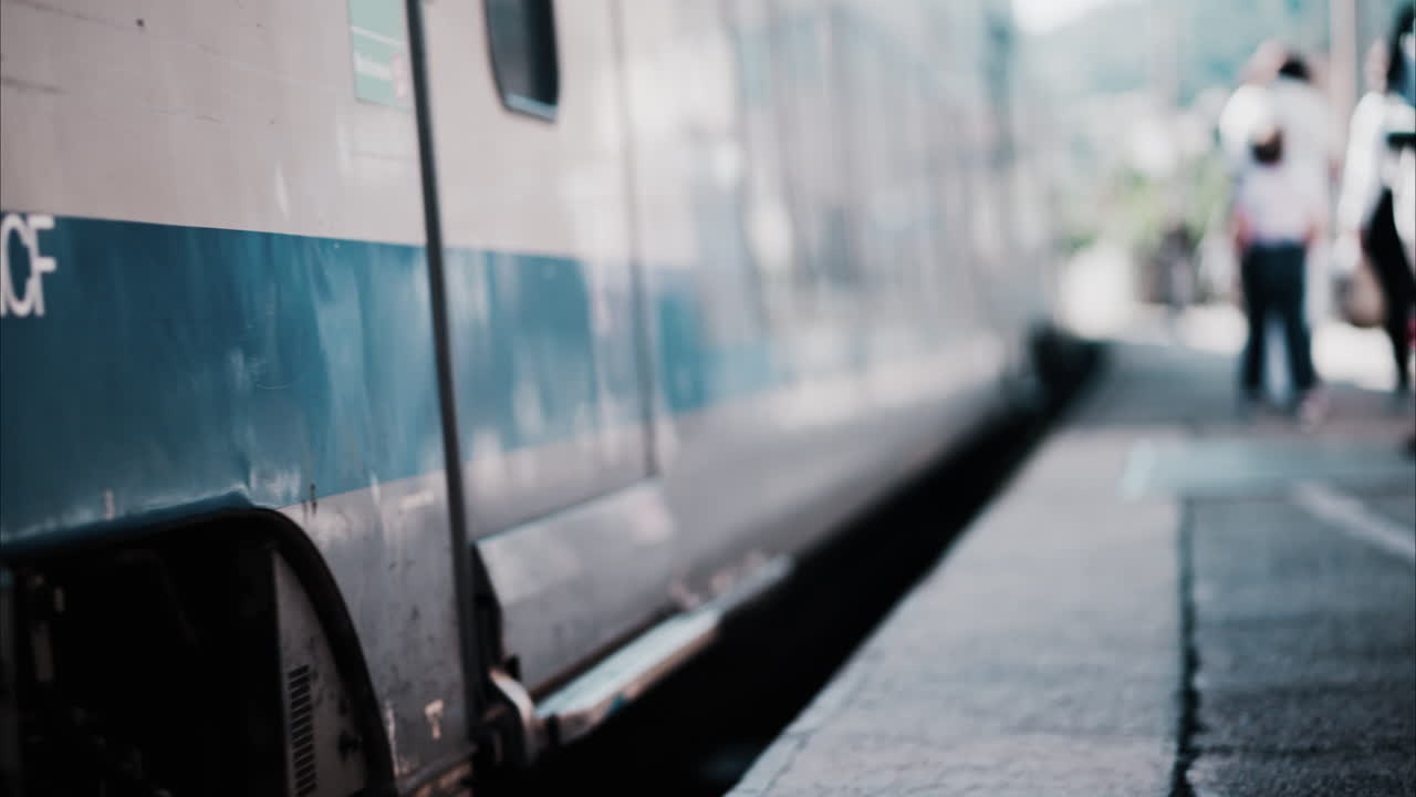 Grey and blue, long train arriving at the station in Antibes, France