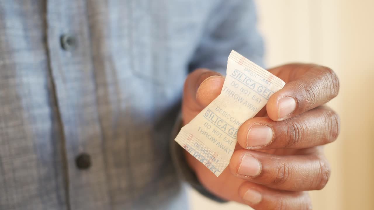 Person holding a silica gel packet