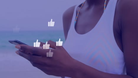 Animation-Von-Social-Media-Reaktionen-über-Den-Händen-Einer-Biracial-Frau,-Die-Ihr-Smartphone-Nutzt