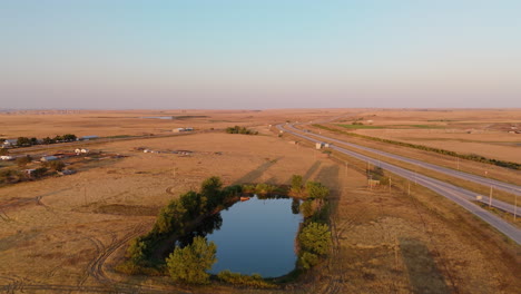 aerial view of rural landscape with highway and pond