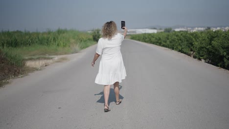 woman taking a selfie on a country road