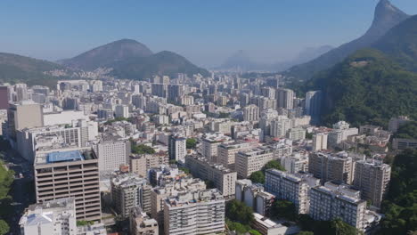 aerial flyover during the day of botafogo neighborhood of rio de janeiro that pans up to reveal the jesus statue