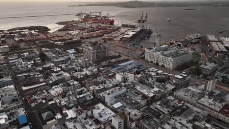 aerial view of a bustling port city with shipping containers and historic buildings