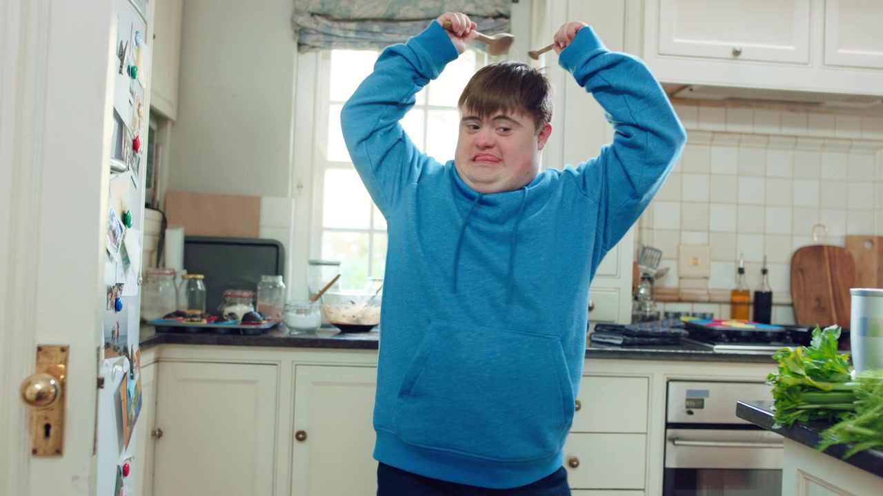 Young Man with Down Syndrome Dancing in Kitchen