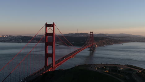drone del puente golden gate sobre el agua al atardecer