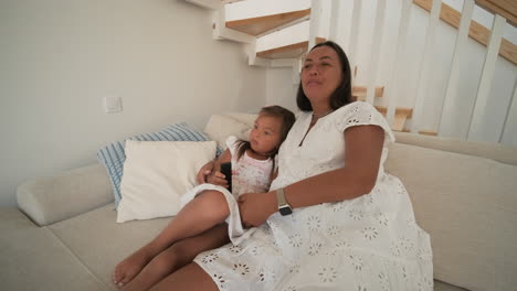 madre y hija felices viendo la televisión