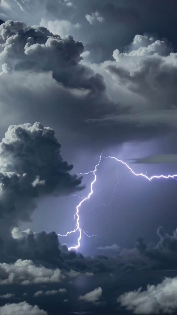 Video verticale: Carica che si accumula in alto in un cumulonembo, scagliando più fulmini e illuminando la base delle nuvole.