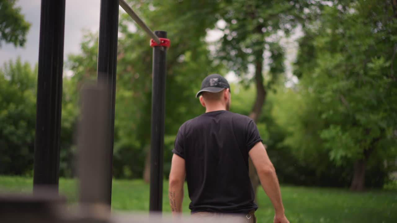 Individual Attaches Elastic Band For Workout, Person Fastens Resistance Loop To Bar For Exercise, Man Meticulously Secures Resistance Band To Bar Before Starting Calisthenics In Park